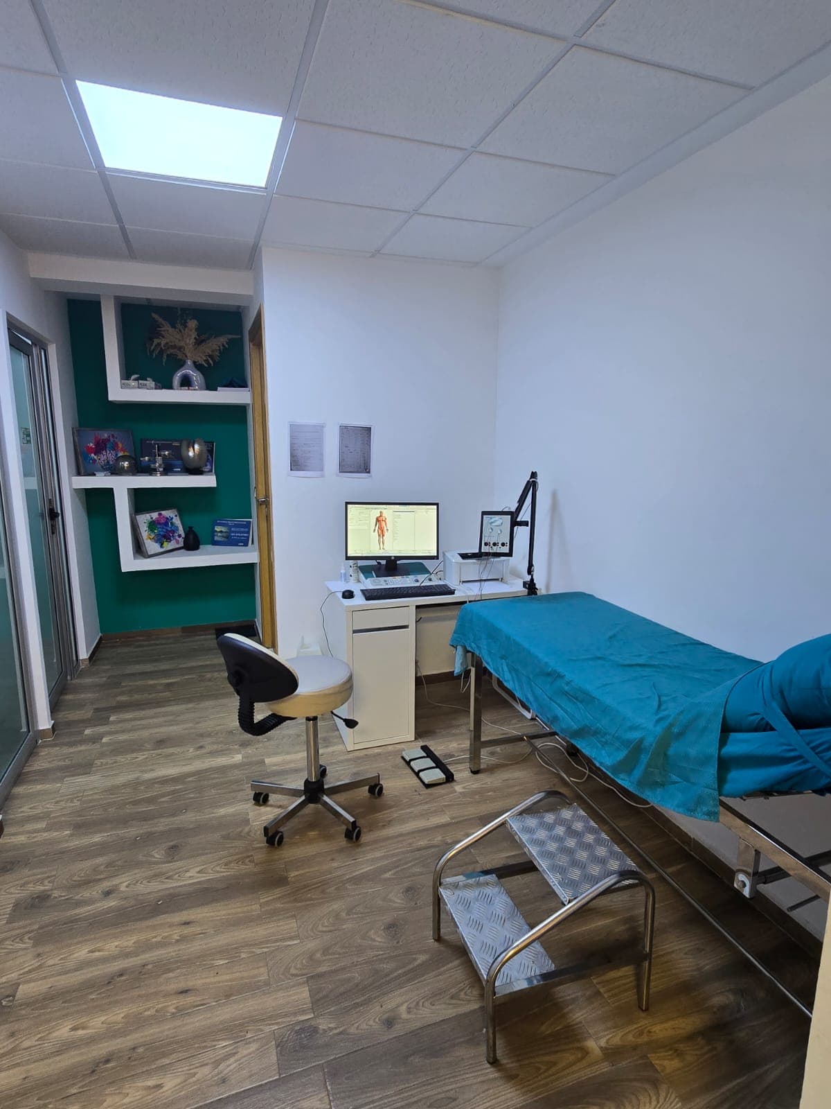Salle d'examen neurologique - lit medical, ordinateur, etageres de decoration